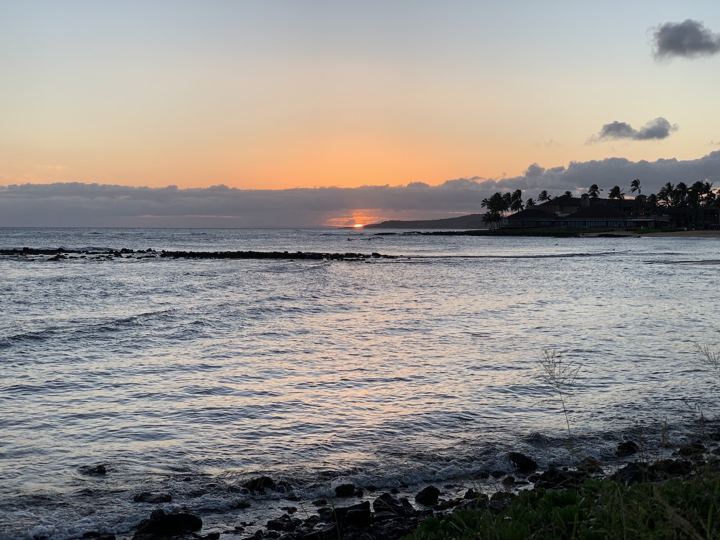 Sunset at Poipu Beach, Kaua&rsquo;i, with the sun hanging on the horizon